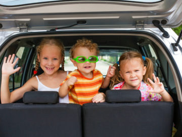 three happy kids in the car